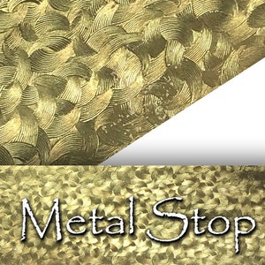 May include: Close-up of a gold-colored metal surface with a repeating, textured pattern of curved lines. The bottom of the image displays the text "Metal Stop" in a stylized font. The overall design suggests a decorative or industrial application.