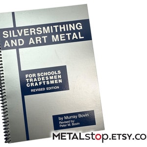 Può includere: Un libro color argento intitolato "SILVERSMITHING AND ART METAL" con rilegatura a spirale nera. La copertina del libro presenta il testo "FOR SCHOOLS TRADESMEN CRAFTSMEN REVISED EDITION" in un rettangolo blu. L'autore è Murray Bovin. Il negozio Etsy è METALstop.ETSY.COM.