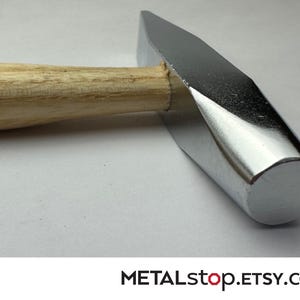 May include: A shiny, silver metal hammer with a wooden handle. The hammer head is rectangular with a flat striking surface. The handle is light brown and cylindrical. The Etsy shop name, METALstop.Etsy.com, is at the bottom.