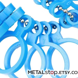 May include: A set of blue plastic ring sizers, connected by a silver chain. The sizers are numbered 6, 6.5, 7, 7.5, 8, 8.5, 9, 9.5, and 10.