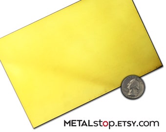 May include: A sheet of bright yellow brass metal. The sheet is approximately the size of a UK 20 pence coin.