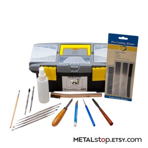 K&ouml;nnte beinhalten: Eine graue und gelbe Werkzeugbox gef&uuml;llt mit Werkzeugen zum Modellieren von Metallton. Die Werkzeuge umfassen eine Vielzahl von Modellierwerkzeugen, einen Pinsel, eine Wasserflasche und einen Satz von drei Metallklingen. Die Werkzeugbox tr&auml;gt ein Etikett mit der Aufschrift "Sculpt Tool Kit for Metal Clay".