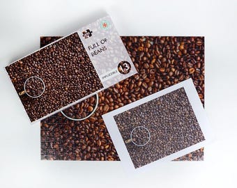 May include: A coffee-themed jigsaw puzzle with the words "FULL OF BEANS" printed on the box. The puzzle and box feature an image of coffee beans. The box also has a magnifying glass graphic and the number 13.