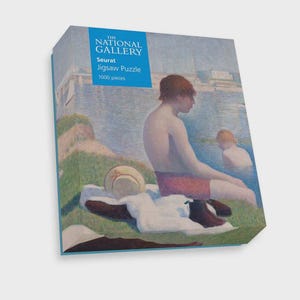 Può includere: Una scatola di puzzle con un dipinto di due persone vicino all'acqua. La scatola ha uno striscione blu con "The National Gallery" e "Seurat Jigsaw Puzzle 1000 pieces". Il dipinto mostra una persona con pantaloncini rossi e un'altra in acqua.