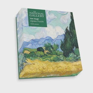 Può includere: Una scatola di puzzle con il dipinto di paesaggio di Van Gogh con montagne, alberi e campi. La scatola ha un bordo verde e un'etichetta che recita "The National Gallery" e "Van Gogh Jigsaw Puzzle 1000 pezzi."