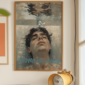Puede incluir: Una pintura enmarcada de un hombre bajo el agua con el texto "Drown in the noise" en letras azules.