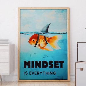 Puede incluir: Impresión artística enmarcada con un pez dorado con aleta de tiburón en agua azul. El texto "MINDSET IS EVERYTHING" está en negro. La obra de arte está en un marco de madera clara.
