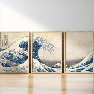 Puede incluir: Un conjunto de tres impresiones enmarcadas que representan una famosa estampa japonesa en madera, "La Gran Ola de Kanagawa" de Katsushika Hokusai. Las impresiones presentan una gran ola con el monte Fuji en el fondo.