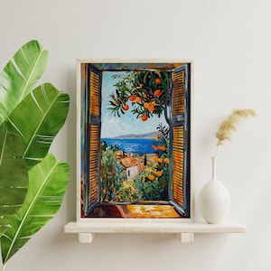 以下が含まれることがあります： 窓から見える海岸の風景を描いた額入りの絵画。青い海、オレンジの木、建物が描かれています。絵画は、花瓶と植物のある白い棚に飾られています。