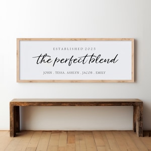 May include: A light wood framed sign with the text "ESTABLISHED 2025" and "the perfect blend" in black script font. Below the text are the names "JOHN, TESSA, ASHLYN, JACOB, EMILY" in black font.