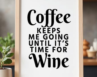 May include: A framed print with the text "Coffee keeps me going until it's time for Wine" in black lettering. The frame is light brown, and the background is white. The print is on a wooden surface.