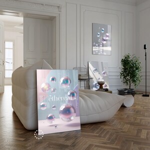 Könnte beinhalten: Ein gerahmter Kunstdruck mit dem Wort "ethereal" und schillernden Blasen. Das Kunstwerk wird in einem modernen Wohnzimmer mit einem großen, weißen, gepolsterten Sofa und Holzböden ausgestellt. Weitere gerahmte Kunstwerke sind sichtbar.
