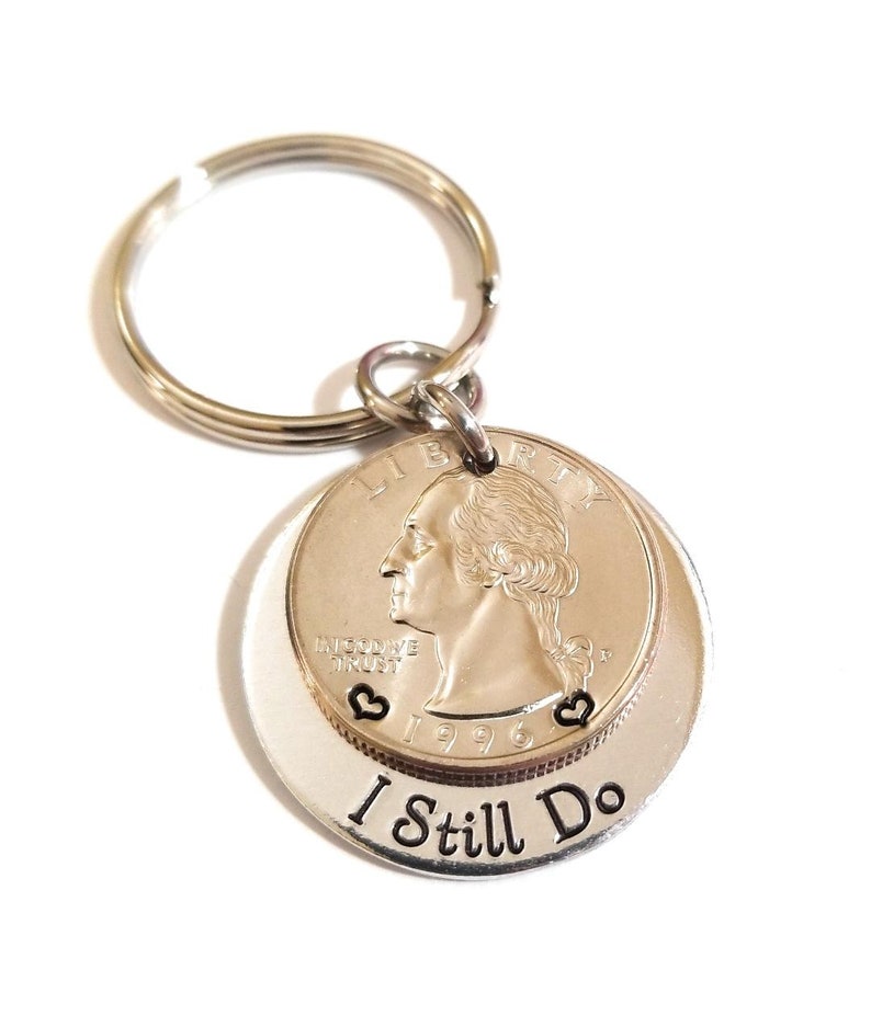 A keychain that hand-stamped "I Still Do" phrase on the bottom aluminum layer and hearts on each side of the year on the 1996 or 1997 quarter