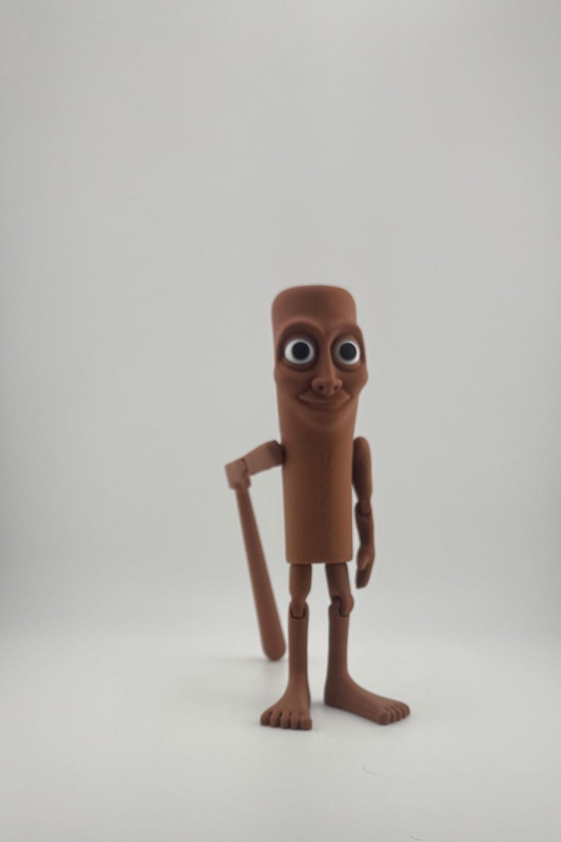 May include: A brown, articulated figurine with a cylindrical body, large eyes, and a smiling face. The figure is holding a brown bat and has articulated arms and legs. The figurine is standing on a white surface.