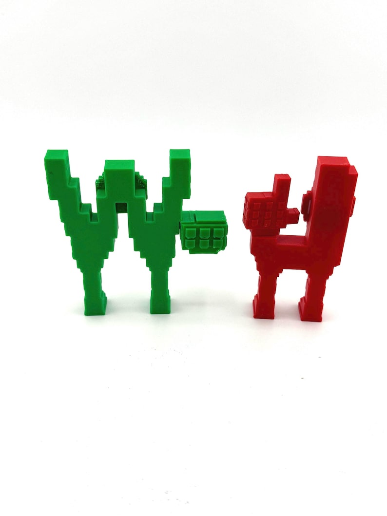 May include: Two pixelated sculptures. One is green and shaped like the letter "W" with a small square attached. The other is red and resembles a dog or similar animal. Both are on a white background.