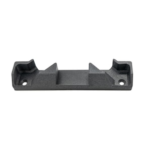 Op de afbeelding: Een donkergrijs, rechthoekig object met een getextureerd oppervlak. Het heeft twee verhoogde secties met schuine randen en twee cirkelvormige gaten. Het object is ontworpen om een ander item vast te houden of te ondersteunen.