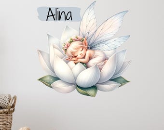 May include: A white and blue fairy with wings sleeps on a white lotus flower. The fairy has blonde hair and is wearing a white dress. The name "Alina" is written in black on a blue background above the fairy.