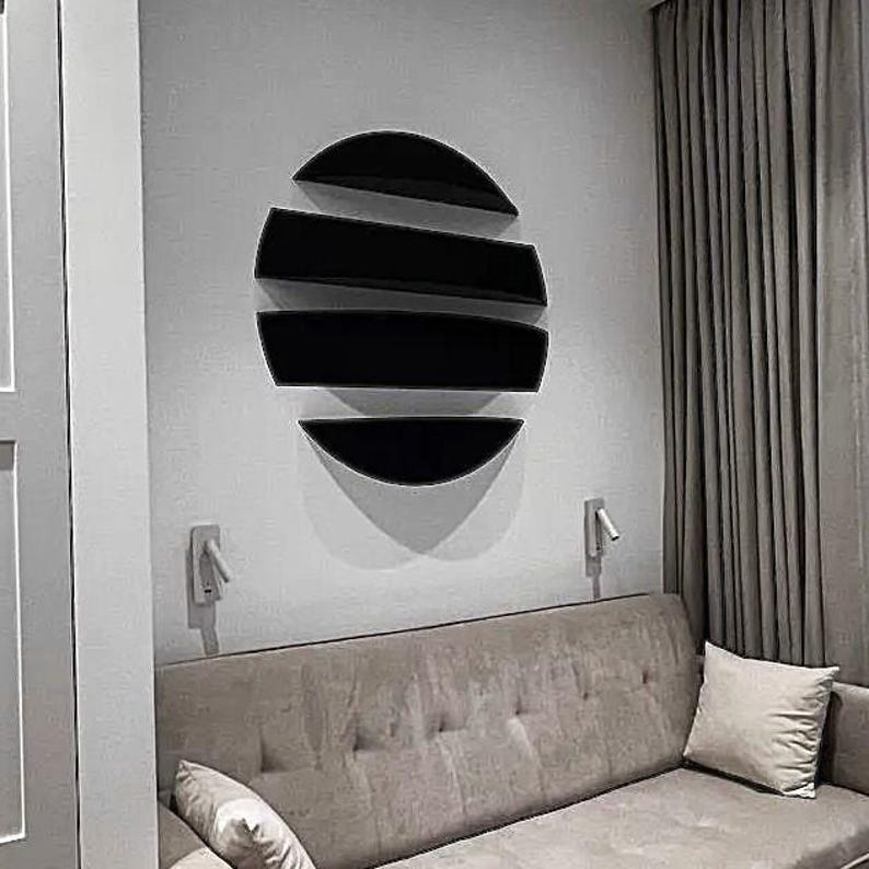 May include: A modern living room scene featuring a black, semi-circular wall shelf arrangement. The shelves are mounted on a light gray wall above a beige sofa with a matching pillow. A gray curtain hangs on the right.