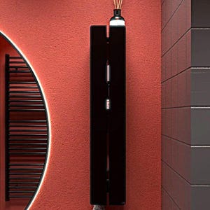 以下が含まれることがあります： モダンなバスルームのシーン。黒いタオルウォーマーと白い光のある丸い鏡があります。壁は鮮やかな赤色で塗装されており、タオルウォーマーの上にはリードディフューザーが置かれています。ミニマリストなデザインです。