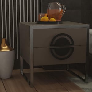 Può includere: Un comodino moderno con finitura marrone e bordi argentati. Ha due cassetti con maniglie circolari nere. Sopra, un vassoio contiene una caraffa di liquido, due bicchieri e limoni. A sinistra, un vaso bianco e oro.