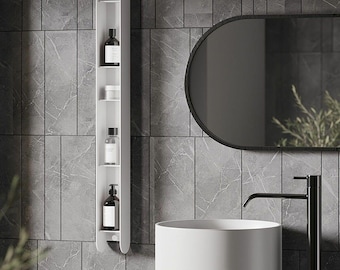 May include: A white, wall-mounted bathroom shelf unit with multiple compartments. The unit holds various dark bottles and containers. The background features a gray tiled wall, a black-framed oval mirror, and a white sink with a black faucet.