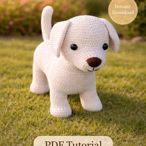 Pode incluir: Um cachorrinho branco de crochê com olhos pretos e nariz castanho está sobre a grama verde. A imagem inclui o texto "Beginner-Friendly Pattern", "Instant Download" e "PDF Tutorial".