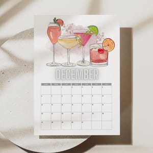 Peut inclure: Un calendrier de décembre avec des illustrations à l'aquarelle de cocktails. Le calendrier présente diverses boissons colorées, chacune garnie de fruits. Le mot "DECEMBRE" est imprimé en grandes lettres grises au-dessus de la grille du calendrier.