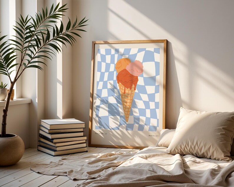 May include: A framed art print featuring an ice cream cone with three scoops in orange and pink hues, set against a blue and white checkered background. The artwork is displayed in a light-colored wooden frame, adding a touch of warmth to the room's decor.