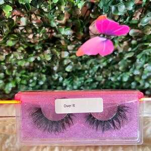 K&ouml;nnte beinhalten: Nahaufnahme eines rosa und durchsichtigen Plastikbeh&auml;lters mit zwei Paaren k&uuml;nstlicher Wimpern. Der Beh&auml;lter tr&auml;gt ein Etikett mit der Aufschrift "Over It".