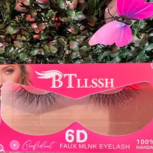 K&ouml;nnte beinhalten: Rosa Verpackung f&uuml;r 6D Faux Mink Wimpern mit dem Markennamen "BTLLSSH" und dem Text "100% HANDMADE" unten. Die Wimpern sind durch ein transparentes Plastikfenster sichtbar.
