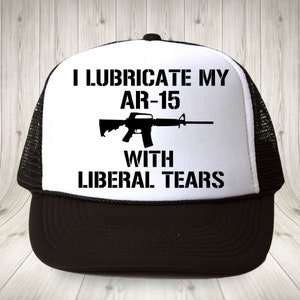 May include: Black and white trucker hat with a white front panel and a black mesh back. The front panel features a black silhouette of an AR-15 rifle and the text "I lubricate my AR-15 with liberal tears."
