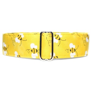 May include: A yellow dog collar with a repeating pattern of bees and white clouds. The collar has a silver buckle.