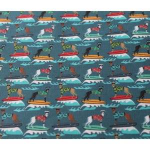 May include: A teal blue fabric with a repeating pattern of dogs wearing sunglasses and Hawaiian shirts riding surfboards on turquoise waves.