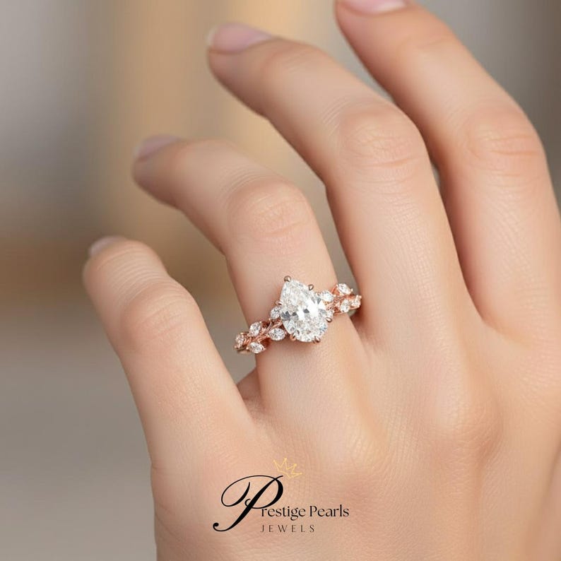 Romantic 2 Ct pear moissanite engagement ring in 14K yellow gold, leaf vine band design with diamond accents, vintage floral bridal jewelry ideal for proposals and anniversaries.