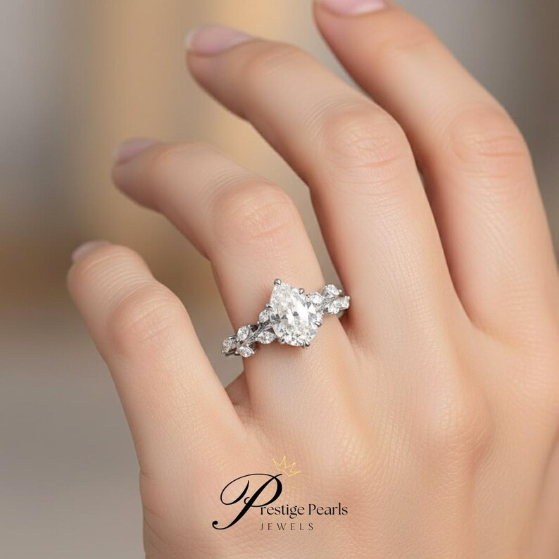 Luxurious 2 Ct pear shaped moissanite engagement ring set in yellow gold, with intricate diamond leaf vine detailing, a nature inspired vintage style ring for brides who adore timeless charm.