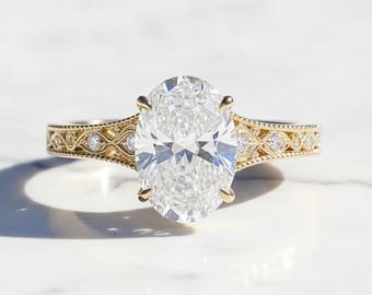 May include: A gold engagement ring with an oval-cut diamond. The ring features a detailed filigree design on the band, accented with small diamonds. The setting is a classic four-prong style, showcasing the large, clear center stone.