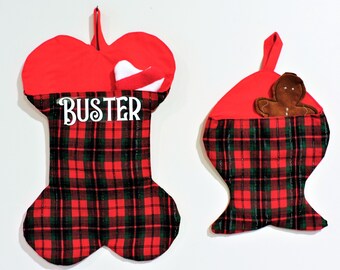 Op de afbeelding: Twee kerstsokken. Eén is botvormig met "BUSTER" in witte letters, rode bovenkant en geruite body. De andere is visvormig met een rode bovenkant en geruite body, met een peperkoekmannetje.