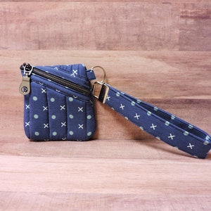 Cartera de muñeca acolchada con estampado de puntos y X en azul marino, llavero pequeño tipo cartera, estuche acolchado para auriculares