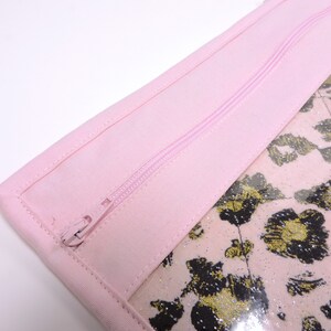 Peut inclure: Une pochette zipp&eacute;e rose avec une fen&ecirc;tre transparente qui r&eacute;v&egrave;le un tissu l&eacute;opard rose et or.
