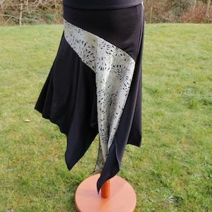 Falda asimétrica negra con panel de estrellas plateadas y sobrefalda de baile