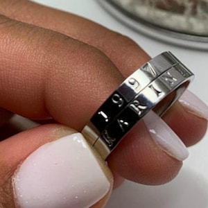 May include: A silver ring with the words "B.ZERO1" and "BVLGARI" engraved on it.