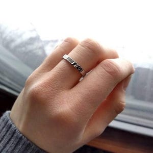 May include: A silver ring with the words "I love you" engraved around the band.