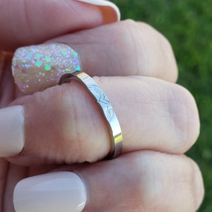 May include: A silver ring with a delicate design of two hearts on the band.