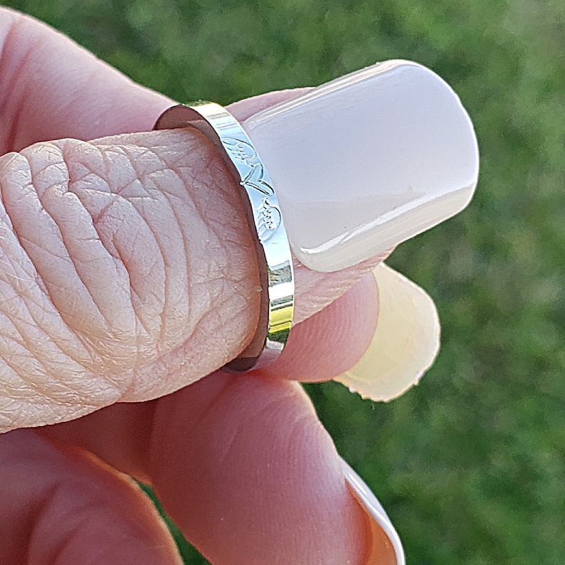May include: A silver ring with a floral design on the band.