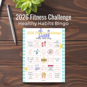 以下が含まれることがあります： 「2026 Fitness Challenge Healthy Habits Bingo」というテキストが入った、フィットネスをテーマにしたビンゴカード。カードには、さまざまな健康関連のアクティビティがグリッド状に表示されています。ペン、ラップトップ、多肉植物も木製の表面に見えます。