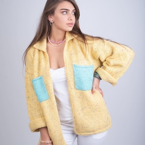 Pastellgul stickad kofta – Handgjord knapplös jacka med blå fickor – Kadaria Brand