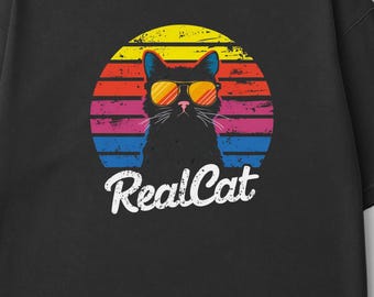 May include: Black t-shirt with a retro sunset graphic featuring a black cat wearing sunglasses and the text "RealCat".