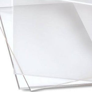 May include: A stack of clear, transparent acrylic sheets. The sheets are rectangular and appear to be of uniform size. The edges of the sheets are visible, showing the thickness of the material. The image is well-lit, highlighting the clarity of the acrylic.