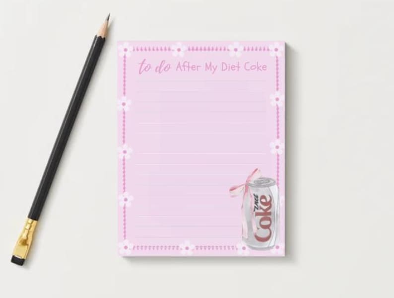 Peut inclure: Bloc-notes rose avec une bordure florale blanche et le texte "to do After My Diet Coke". Une canette argent&eacute;e de Coca-Cola light avec un ruban rose se trouve dans le coin inf&eacute;rieur droit.