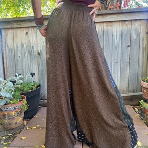 May include: Wide-leg pants with a brown and black patterned fabric. The pants have a high waist and a relaxed fit. The fabric has a subtle shimmer.